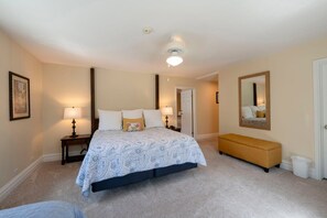 A bedroom with a bed, bedside lamps, a bench, a mirror, and a door. - Resort Center 5004 | Ski-In/Ski-Out | Pool & Hot Tub Access | Fireplace | Elevator | 1,700 Sq Ft (Park City)