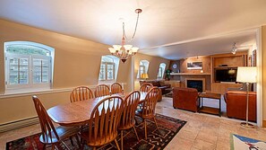 A dining area with a wooden table and chairs, a chandelier, and a fireplace. - Resort Center 5013 | Ski-In/Ski-Out | Pool & Hot Tub Access | Fireplace | 3 Baths | Sleeps 8 (Park City)