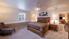 A bedroom with a large bed, a chair, a nightstand, a ceiling fan, a window, and a wall decoration. - Resort Center 5013 | Ski-In/Ski-Out | Pool & Hot Tub Access | Fireplace | 3 Baths | Sleeps 8 (Park City)