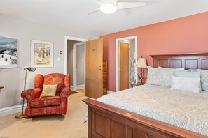 A bedroom with a large bed, a red patterned armchair, a standing lamp, and a ceiling fan. - Resort Center 5064 | Ski-In/Ski-Out | Pool & Hot Tub Access | Renovated | Fireplace | Laundry (Park City)