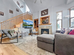 A modern living room with a staircase, a fireplace, and a television. - Fox Pointe A2 | Redstone Village | Walk to Shops & Dining | Garage | Fireplace | Patio & Grill | A/C (Park City)