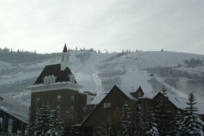 A building with a steep roof, surrounded by snow-covered trees and a hill with a ski lift in the background. - Resort Center 5025 | Ski-In/Ski-Out | Pool & Hot Tub Access | Renovated Baths | Fireplace | Roku (Park City)