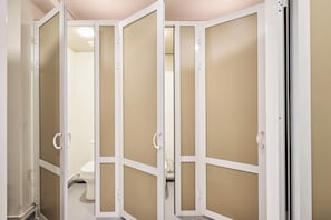 A bathroom with a toilet, a sink, and a shower area. - As Home Hostel (Tashkent)