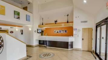A reception area with a counter, a clock, and a door.