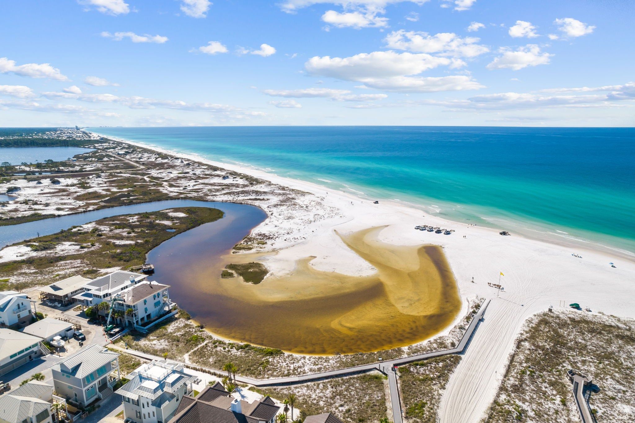 A coastal property with a beach, a marina, and a road leading to the beach.