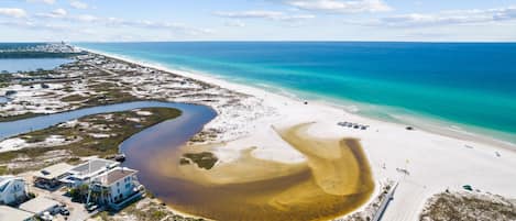 A coastal property with a beach, a marina, and a road leading to the beach.
