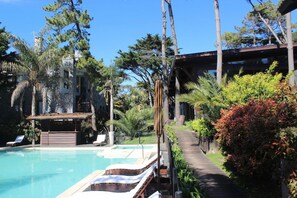 A pool area with lounge chairs and a wooden deck. - Rincon del Duende (Mar de Las Pampas)