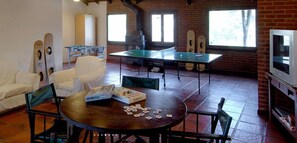 A room with a ping pong table, a sofa, a table with playing cards, and a television. - Rincon del Duende (Mar de Las Pampas)