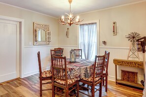 A dining room with a wooden table, chairs, a chandelier, a windmill decoration, and a mirror on the wall. - 1/2 Mi to Marina! Lake George Group Getaway (Diamond Point)