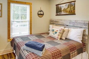 A bedroom with a bed, a window with blinds, a wall-mounted decoration, and a painting. - 1/2 Mi to Marina! Lake George Group Getaway (Diamond Point)