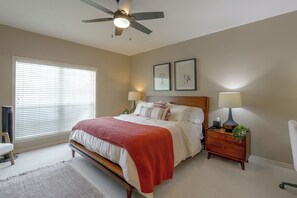 A bedroom with a bed, two bedside lamps, a ceiling fan, a window with blinds, and two framed pictures on the wall. - Walk to Texas A&M! Quiet Home w/ Fenced Yard (College Station)