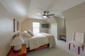 A bedroom with a bed, a chair, a ceiling fan, and a window. - Walk to Texas A&M! Quiet Home w/ Fenced Yard (College Station)