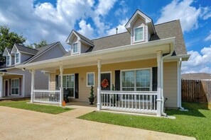 A two-story house with a covered porch, a front door with a cross, and a mailbox. - Walk to Texas A&M! Quiet Home w/ Fenced Yard (College Station)