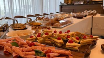 Une table de buffet garnie de divers plats, avec un mur de pierres en arrière-plan.