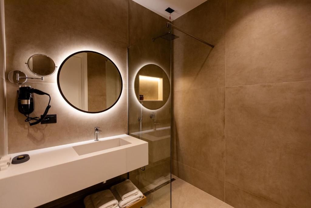 Un baño moderno con un espejo grande, un lavabo y una ducha.