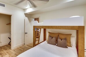 A bunk bed with a wooden frame and white bedding, a wooden ladder, and a white door leading to a closet. - Walk to Beach! Condo w/ Shared Rooftop Patio (Oceanside)