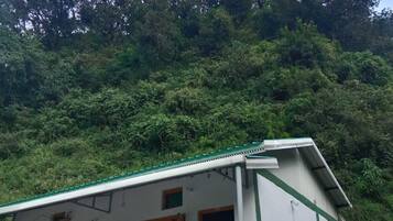 A building with a green roof, white walls, and a balcony with yellow railings.
