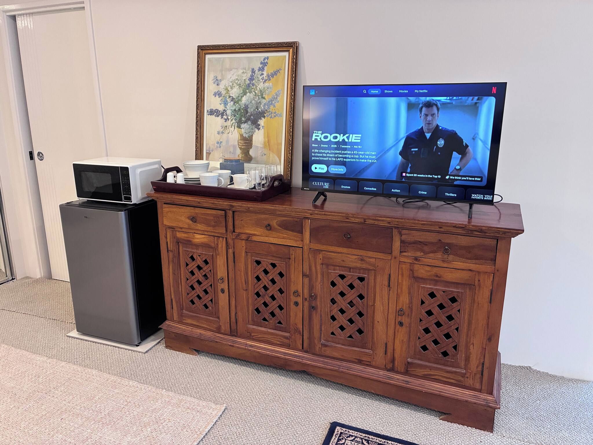 A wooden cabinet with a television on top displaying a show.
