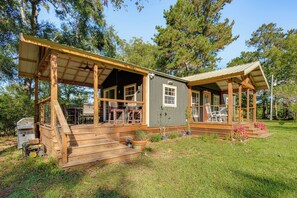A wooden cabin with a porch, outdoor seating, and a grill area. - On 80 Acres! Serene Orchard Farm Stay in Lumberton (Lumberton)