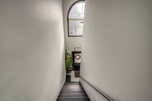 A narrow stairway leading to a door with a window above it. - Group Getaway in Paterson, Close to NYC (Paterson)
