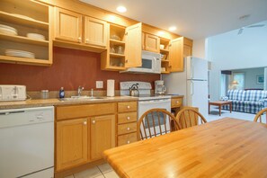 A compact kitchen with wooden cabinets, a microwave, a coffee maker, and a dishwasher. - Retreat 2 Mi to Cape Cod Beaches! Bring Your Pets (Mashpee)
