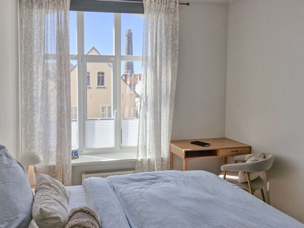 Quarto com cama, escrivaninha e cadeira.