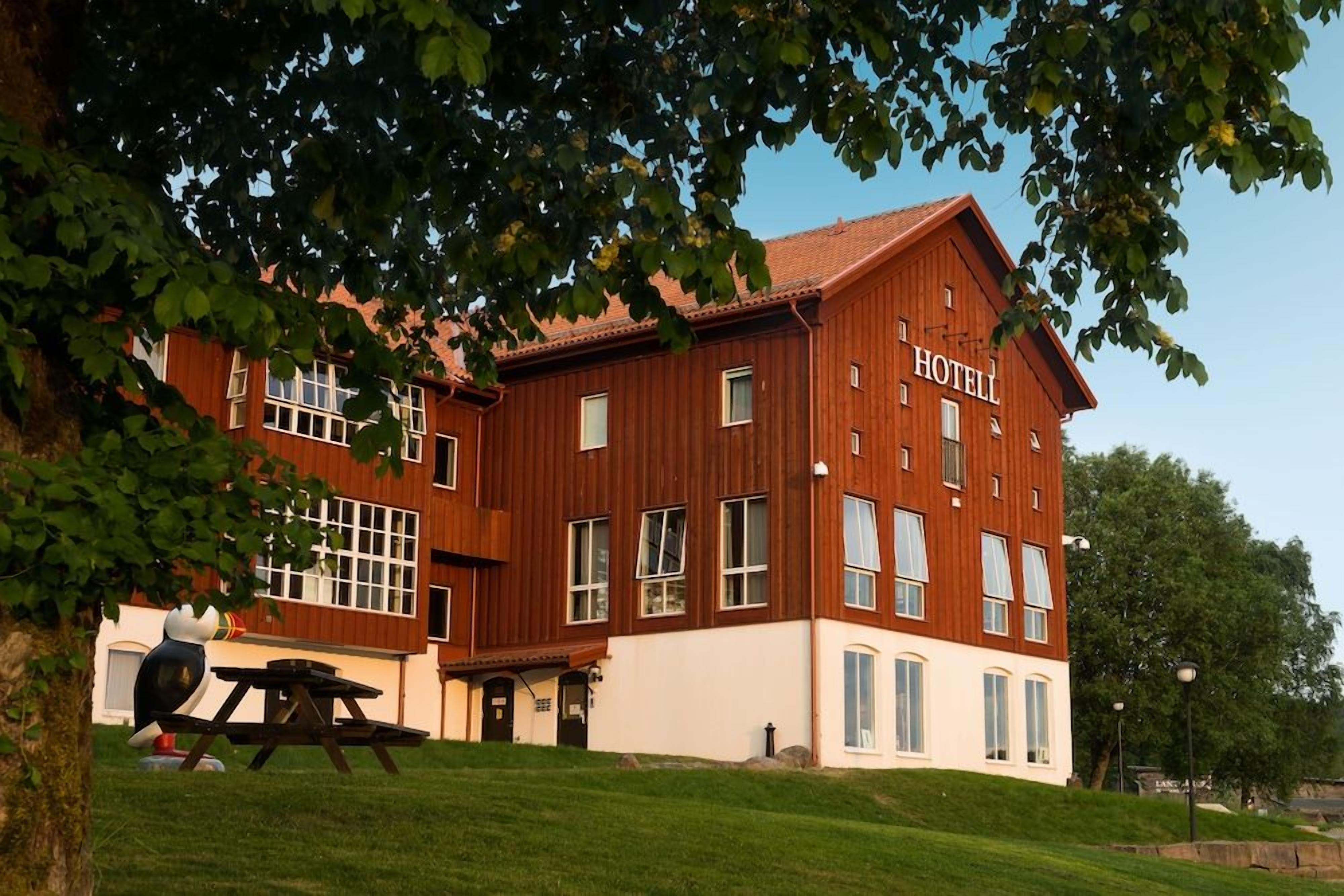 En toetages træbygning med et skilt, der viser ordet 'HOTEL' på facaden.