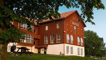 En toetages træbygning med et skilt, der viser ordet 'HOTEL' på facaden.