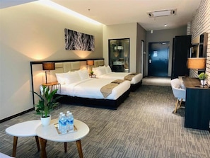 Habitación de hotel con una cama grande, mesitas de noche, un escritorio y una silla.