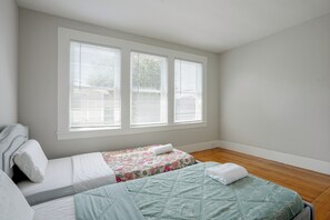 A bedroom with two beds, a window with blinds, and a wooden floor. - 1 Mi to Beach, Walk to Restaurants Cozy Home (Alameda)