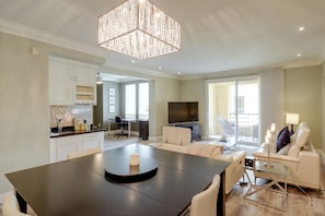 A modern living room with a dining area, a kitchen, and a balcony. - Las Vegas Condo Just Off the Strip (Las Vegas)