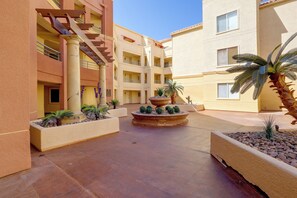 A multi-level building with a central courtyard featuring a fountain and potted plants. - Las Vegas Condo Just Off the Strip (Las Vegas)