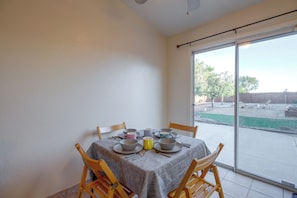 A dining area with a table set for four, chairs, and a view of the backyard through a sliding glass door. - 37 Min to Tesla Gigafactory! Sun Valley Home (Sun Valley)
