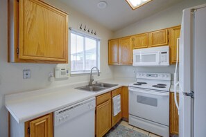 A kitchen with wooden cabinets, a white countertop, a built-in microwave, a stove, and a dishwasher. - 37 Min to Tesla Gigafactory! Sun Valley Home (Sun Valley)