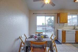 A kitchen with a dining table set for four, a ceiling fan, and a view of the backyard through a sliding glass door. - 37 Min to Tesla Gigafactory! Sun Valley Home (Sun Valley)