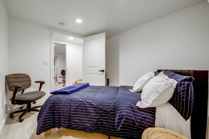A bedroom with a bed, a chair, and a door leading to another room. - Snohomish Executive Suite w/ Deck & Fire Pit (Snohomish)