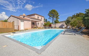 A swimming pool with lounge chairs and a building with a tiled roof. - Beautiful apartment in Folelli with WiFi (Folelli)