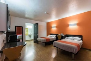 Una habitación de hotel con dos camas, un escritorio y una silla.