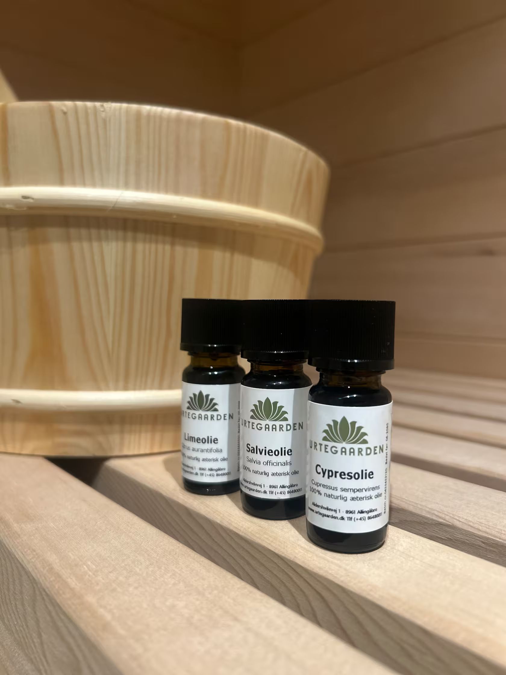 Tres frascos pequeños de aceites esenciales sobre una superficie de madera.
