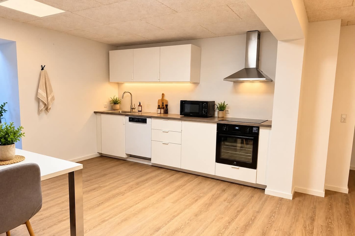 A modern kitchen with white cabinetry, a built-in dishwasher, a microwave, and an oven.