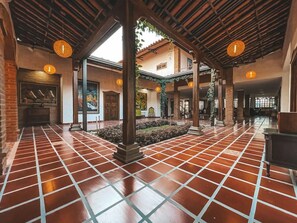 A spacious interior with a tiled floor, wooden beams, and hanging lights. - Hotel Casona Montañesa Quindío (Montenegro)