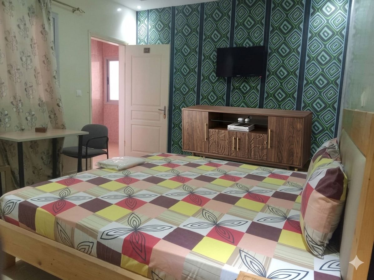 Un dormitorio con una cama, un armario de madera, un televisor y un escritorio.