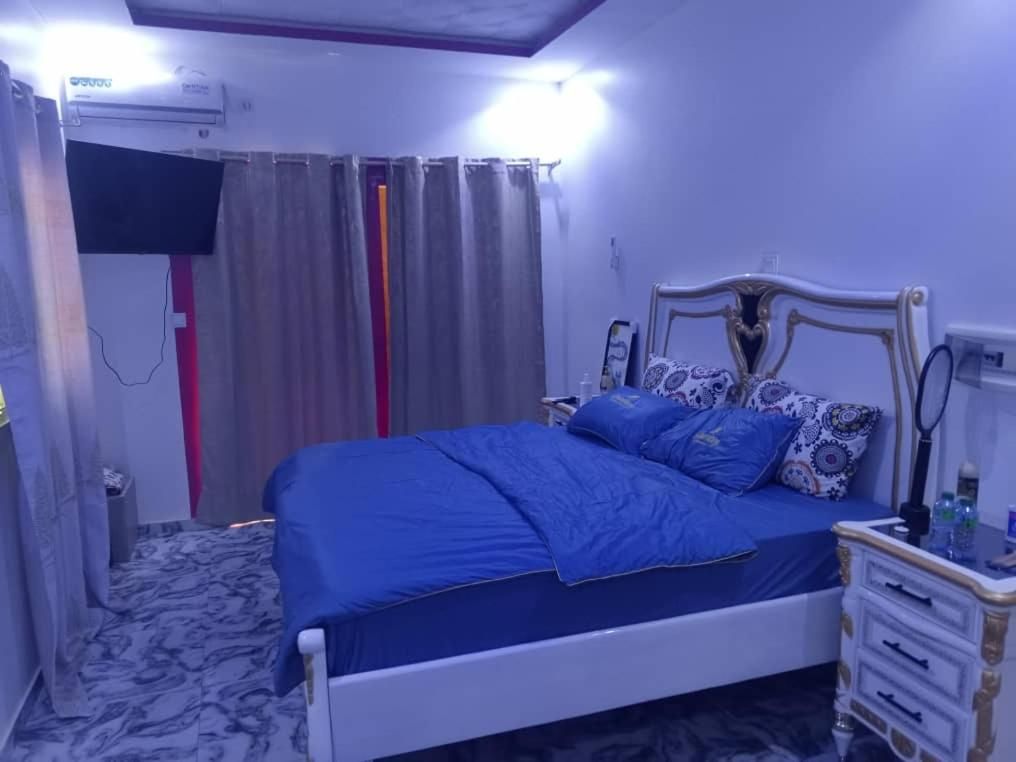 Une chambre à coucher avec un lit, des rideaux, une table de chevet et un climatiseur fixé au mur.
