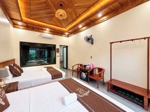 A hotel room with two beds, a sitting area with a table and chairs, a view of the outside through a large window, and a wooden ceiling. - Trang An Lucky Homestay (Tây Hoa Lư)