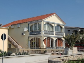 A two-story building with a red-tiled roof, multiple balconies, and a staircase leading to the entrance. - Holiday Home in Vir With Swimming Pool (Vir)