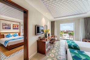 Habitació d'hotel amb llit, escriptori, cadira, televisió i balcó amb vistes.