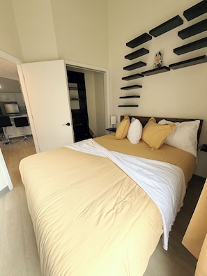 A bedroom with a bed, bedside table, and a wall-mounted shelf.