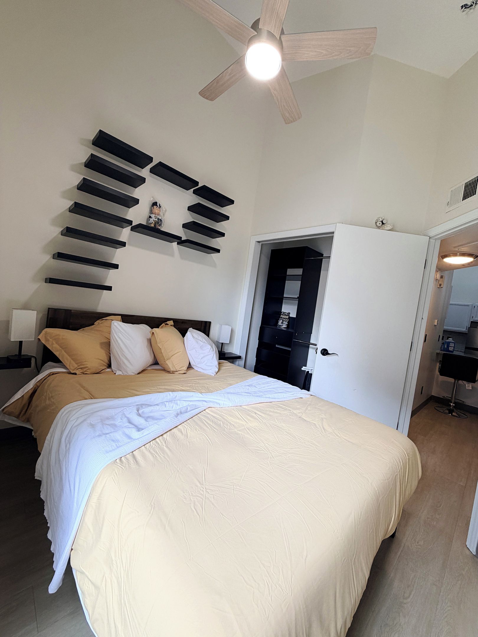 Ein Schlafzimmer mit einem Bett, einem Deckenventilator und einem Kleiderschrank.