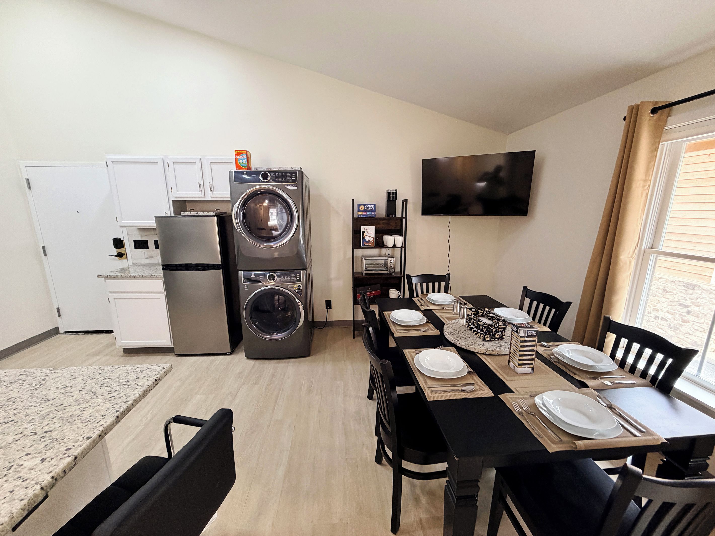 Unit 6 Kitchen showing fridge, in unit washer and dryer, and bookshelf with Keurig, k-cups, toaster, and tea.