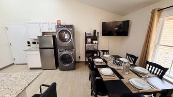 Unit 6 Kitchen showing fridge, in unit washer and dryer, and bookshelf with Keurig, k-cups, toaster, and tea.